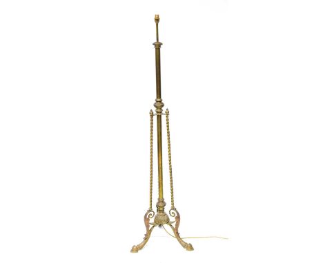 A Victorian brass standard lamp with three twist columns surrounding a central column, on tripod base with hoof feet, height 