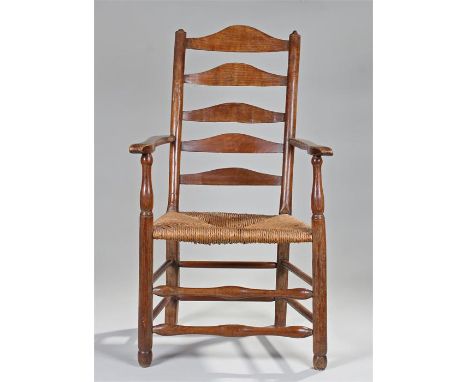 19th Century ash armchair, of large proportions, the arched ladder back with shaped arms and rush seat raised above turned le