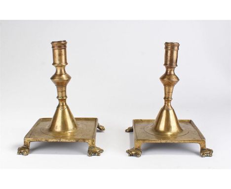 Pair of early 18th Century Spanish candlesticks circa 1710, each with the candle holder above a shaped stem and wide square b