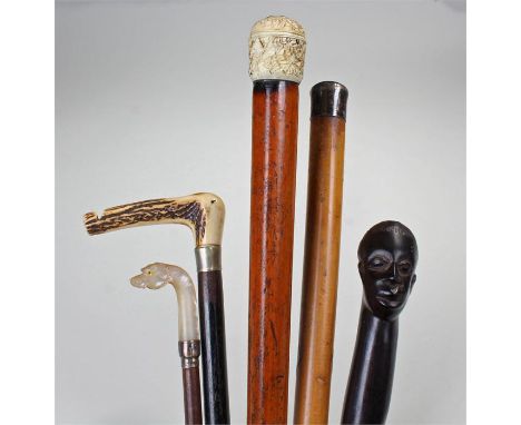 Collection of five walking sticks/canes, to include a carved hardwood African example, a late 19th Century Chinese carved ivo