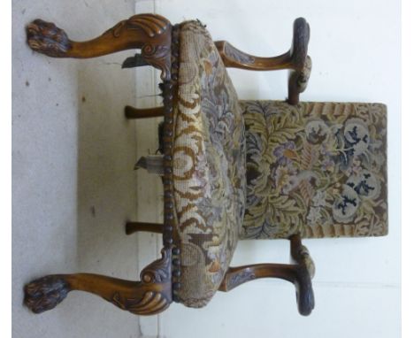 An early 20thC Georgian style mahogany framed elbow chair, having a square back, the open arms with carved, scrolled and feat