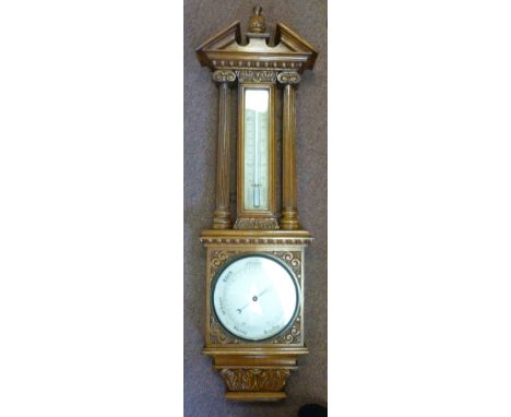 A late Victorian aneroid barometer and thermometer, set in a light oak backplate, having a broken arch pediment, over pillare
