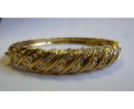 An 18ct gold bangle of wrythen design, set with diamond 