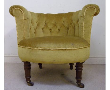 A late Victorian tub chair, having a horseshoe shaped back and an overstuffed seat, part button upholstered in yellow dralon,