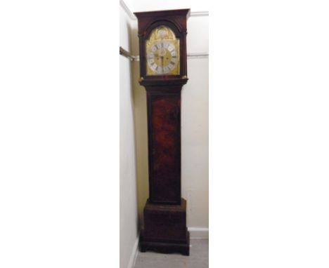 An early 18thC walnut longcase clock, the hood having a moulded pediment, over an arched door with turned pillars and rectang