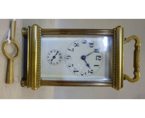 A mid 20thC lacquered brass cased carriage clock, having bevelled glass panels and a folding top handle, on turned feet; the 