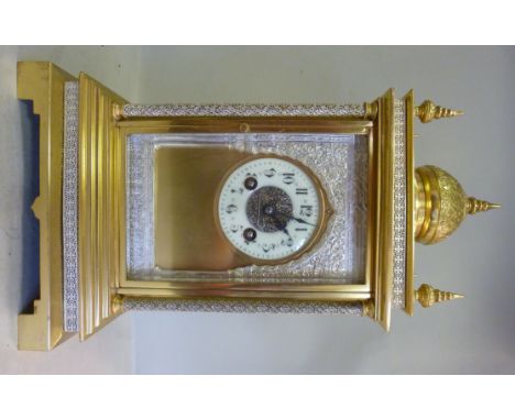 A 20thC Middle Eastern lacquered brass and finely cast white coloured metal cased mantel clock, having a domed top with finia