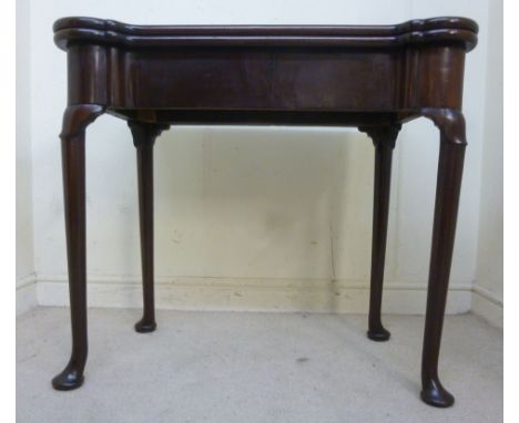 A late 18thC mahogany games table with outset turret corners and a foldover top, enclosing a plum coloured, baise lined inter