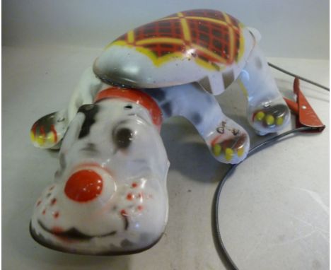 A Mobo 'Scottie' painted tinplate 'Scamper Along' toy dog, on fibre wheels with manual activation