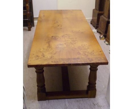 A modern, bespoke reproduction of an Old English burr elm and oak dining table, the light coloured planked top raised on balu