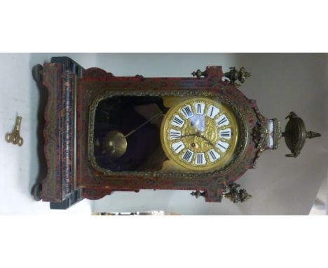 A late 19thC ebonised, red boulle cased bracket clock with brass mounts, having a pagoda top, surmounted by an urn, flanked b