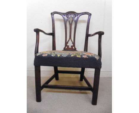 A late 18thC Chippendale design, mahogany framed elbow chair, having a foliate carved and scrolled crest, over a pierced ribb