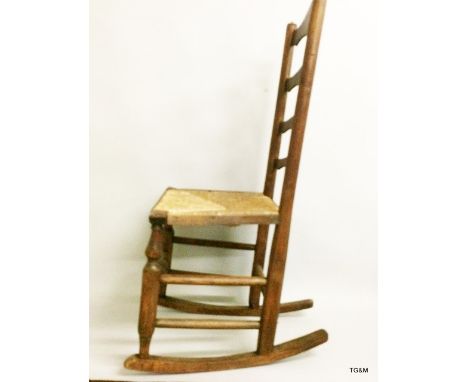 A rattan seated ladder back elm country rocking chair 