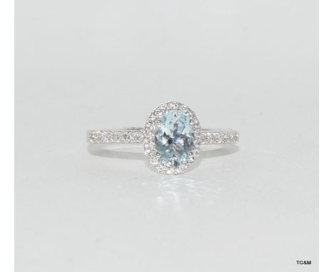 an 18ct white gold aquamarine and diamond cluster of 1.1ct Size M