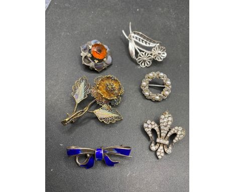 Six silver brooches including enamel gilt and seed pearl examples