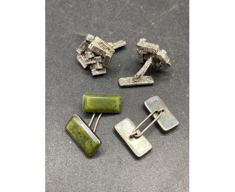A silver designer cufflinks together with jade and silver cufflinks