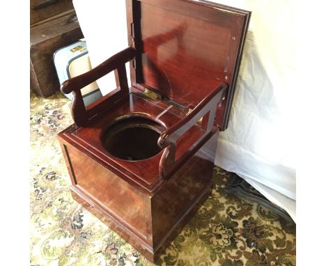 A mahogany commode with folding arm rests a throne indeed.