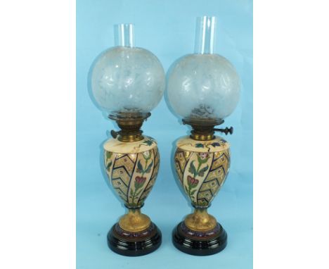 A pair of Victorian ceramic oil lamps, each with etched globe shade, 62cm high, (1 damaged), (2).