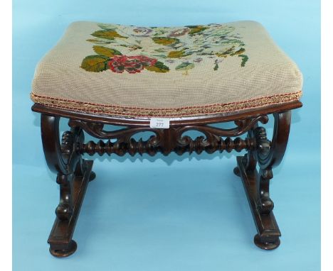 A George IV rosewood stool, the concave shaped seat with carved detail, on X-shaped end supports joined by a turned stretcher