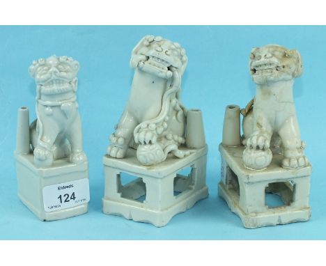 A group of three early-18th century Chinese blanc de chine porcelain Buddhistic lion joss stick holders, the lions crouching 