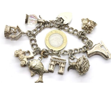 Hallmarked silver charm bracelet with padlock clasp and eight large charms. P&amp;P Group 1 (£14+VAT for the first lot and £1