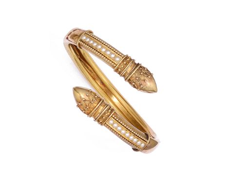 ARCHEOLOGICAL REVIVAL GOLD AND SEED PEARL BANGLE, 1860s of cross over design, the pointed terminals decorated with applied wi