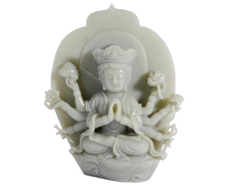 A CHINESE CELADON JADE FIGURE OF GUANYIN the eight-armed deity seated in front of a lotus-shaped aureole, wearing a long flow