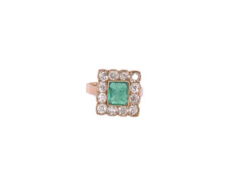 EMERALD AND DIAMOND RING of cluster design collet set to the centre with a step-cut emerald within a surround of cushion shap