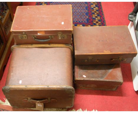 An early 20th century canvas, wooden and metal bound travelling trunk, together with three various tan leather suitcases (4)