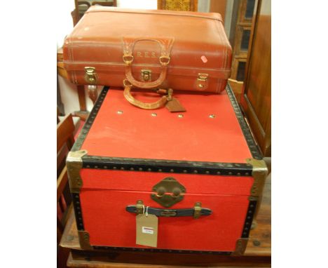 A red canvas and metal bound travelling trunk; together with a tan vellum suitcase (2)