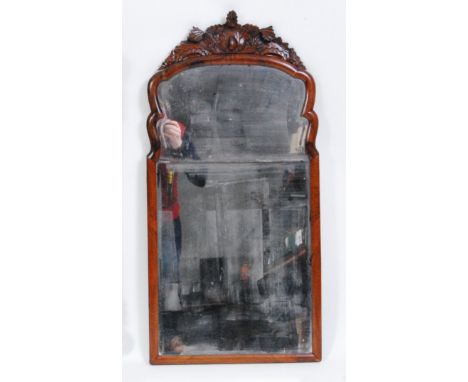 An early 19th century walnut framed wall mirror, the two bevelled plates surmounted by a leaf carved pediment, h.96cm, w.47cm
