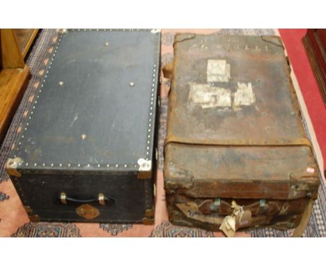 An early 20th century tan leather travelling trunk, together with a canvas clad example (2)