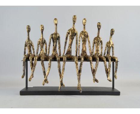 A study of seven people on a bench, each holding the other's hand 