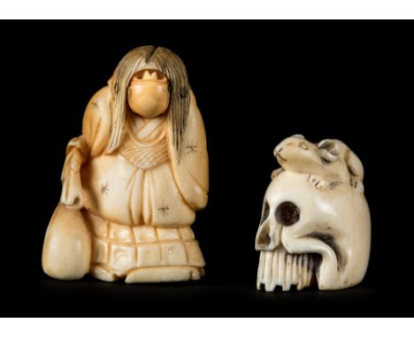 *Netsuke. An early 20th century Japanese ivory netsuke,  carved as a rat on a human skull, signed to rear, 3 cm high, togethe