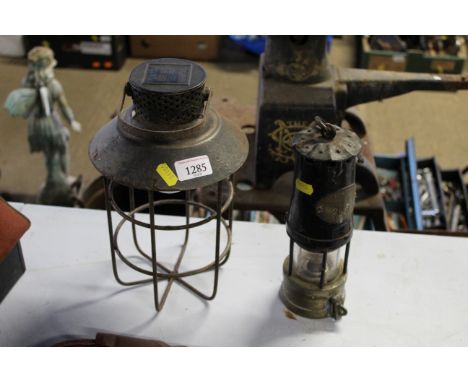 A vintage miners lamp and a hanging solar-powered lamp