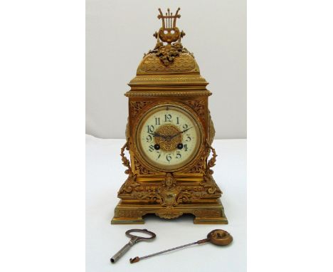 A French gilt metal mantle clock of pierced rectangular form with two train movement, enamel dial with Arabic numerals all on