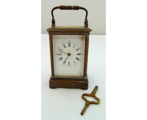 A brass carriage clock of customary form with white enamel dial and Roman numerals, 16.5cm (h)