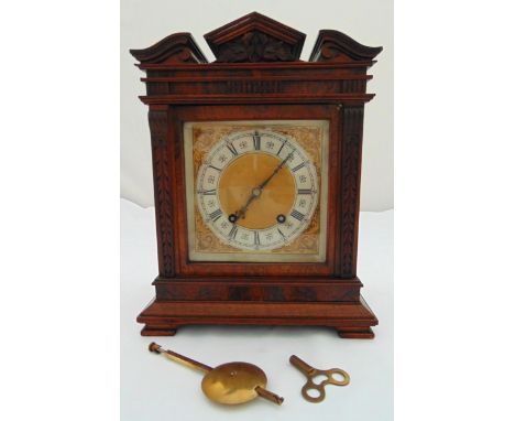 An Edwardian mantle clock, two train movement silvered dial with Roman numerals on four bracket feet to include pendulum and 
