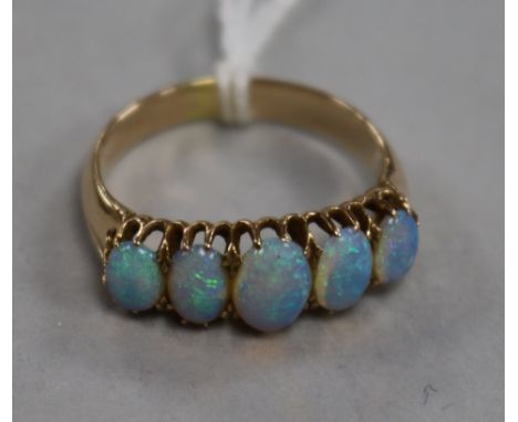 A yellow metal and graduated five stone white opal ring, size O.