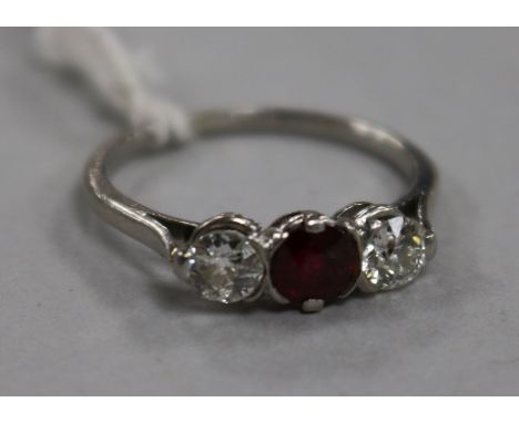 A white metal, ruby and diamond three stone ring, size M/N.