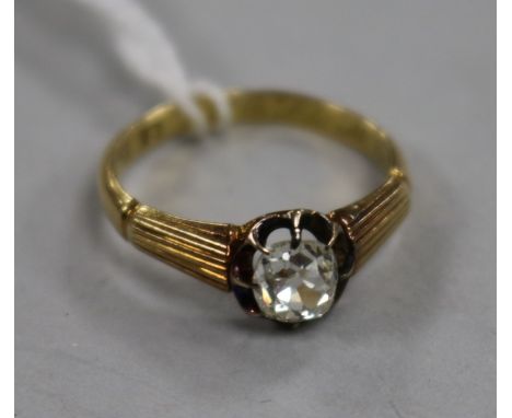 A 20th century 18ct gold and claw set solitaire diamond ring with reeded shoulders, size K.