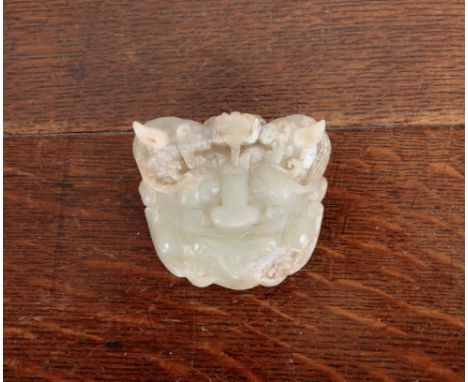 A CHINESE ARCHAISTIC CARVED JADE BELT BUCKLEmodelled as taotei mask, 7cm wideWidth: 7.5cm