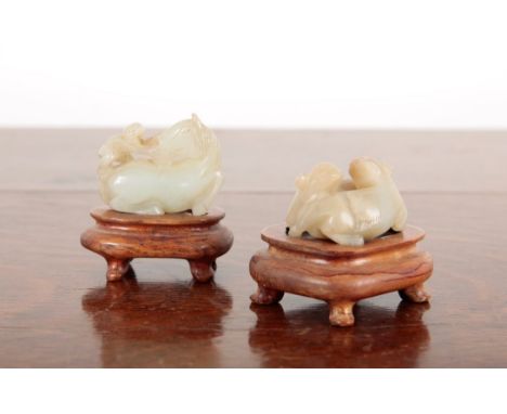 TWO CHINESE JADE GROUPSincluding a monkey riding a horse, 4.5cm long, and a feline group, 3.5cm wide, both on wooden stands (