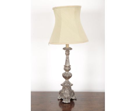 A BAROQUE STYLE SILVERED TABLE LAMP with a turned and moulded stem on a tripod base, 54cm high to the bottom of the electrica