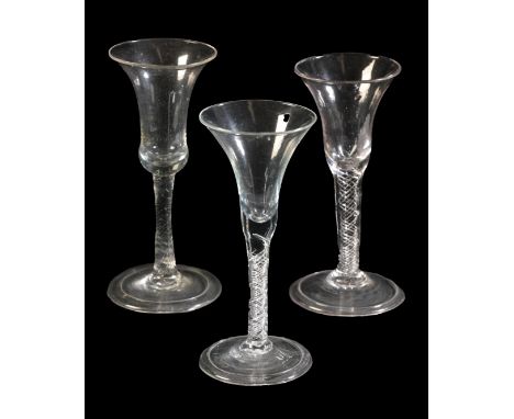 A GROUP OF THREE SIMILAR 18TH CENTURY ENGLISH WINE GLASSESc.1750, two with bell bowls on air twist stems, 16.5cm and 17cm hig