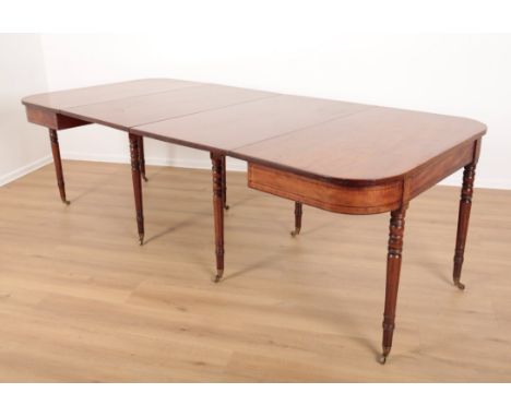 A GEORGE IV MAHOGANY DINING TABLEthe two ebony strung D-shape ends on ring turned legs terminating in brass toes and castors,