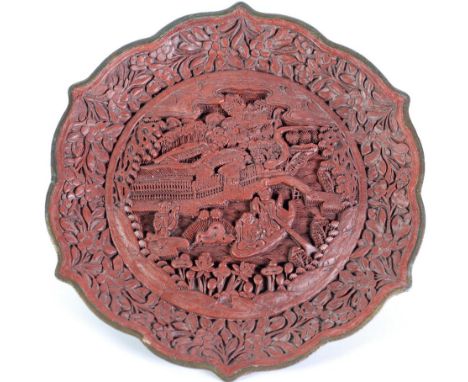 CHINESE CINIBAR LACQUER SHALLOW DISH, of circular form with gilt cyma rim, decorated with figures, foliage and swellings in a