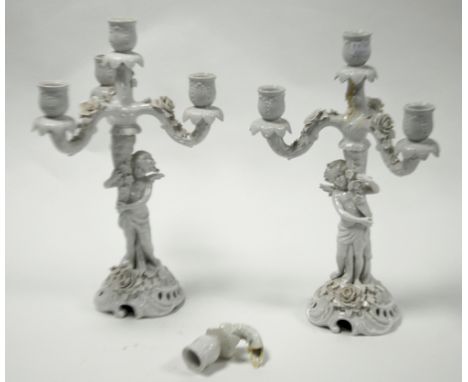 PAIR OF AUSTRIAN WHITE GLAZED PORCELAIN FIGURE FOUR LIGHT, THREE BRANCH CANDELABRA'S, each modelled as a winged cherub holdin