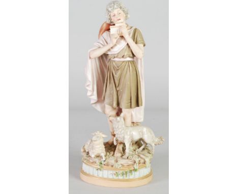 ROYAL DUX PORCELAIN GROUP, painted in muted tones and gilt, and modelled as a shepherd playing pan pipes, with a lamb and dog