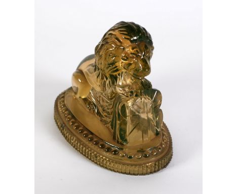VICTORIAN PALE GREEN TINTED PRESSED GLASS MODEL OF A LION,  by John Derbyshire, modelled with front paws raised on a Union Ja